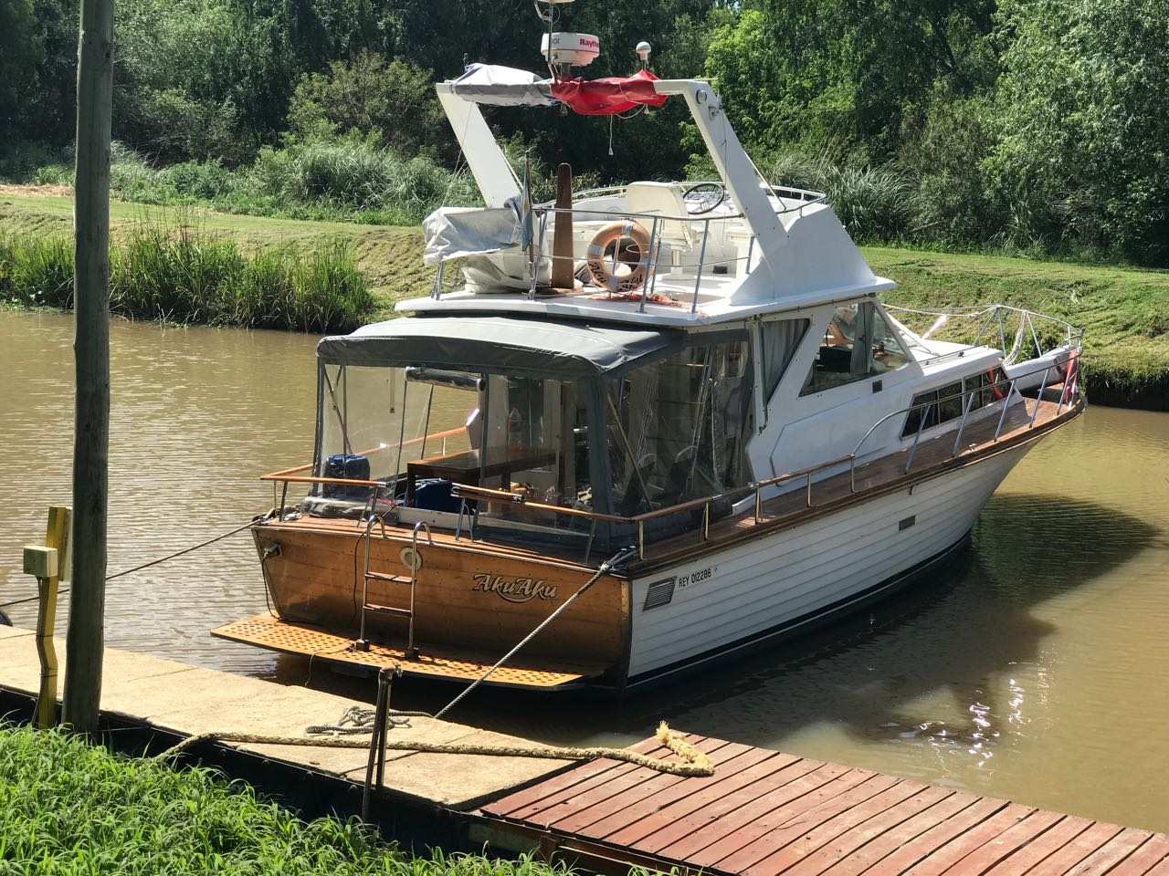 Crucero de madera amarrado al muelle sobre el arroyo